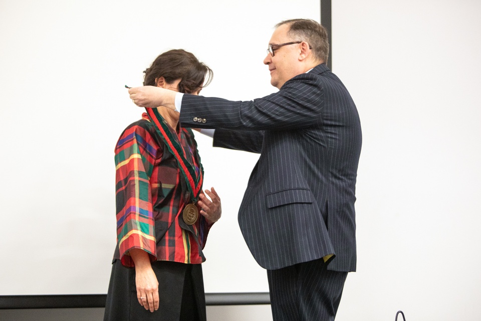Man bestows medallion on woman.