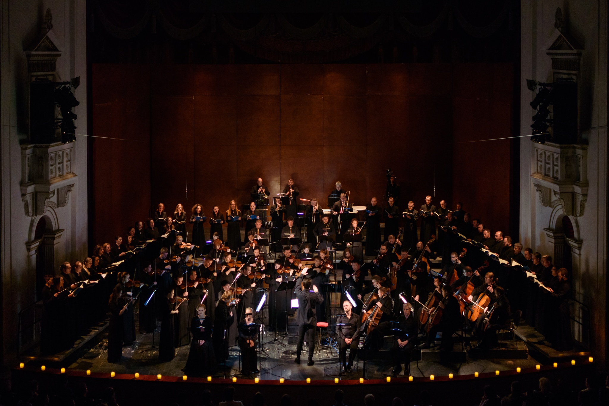 A portrait of the musicAeterna orchestra and choir performing on stage