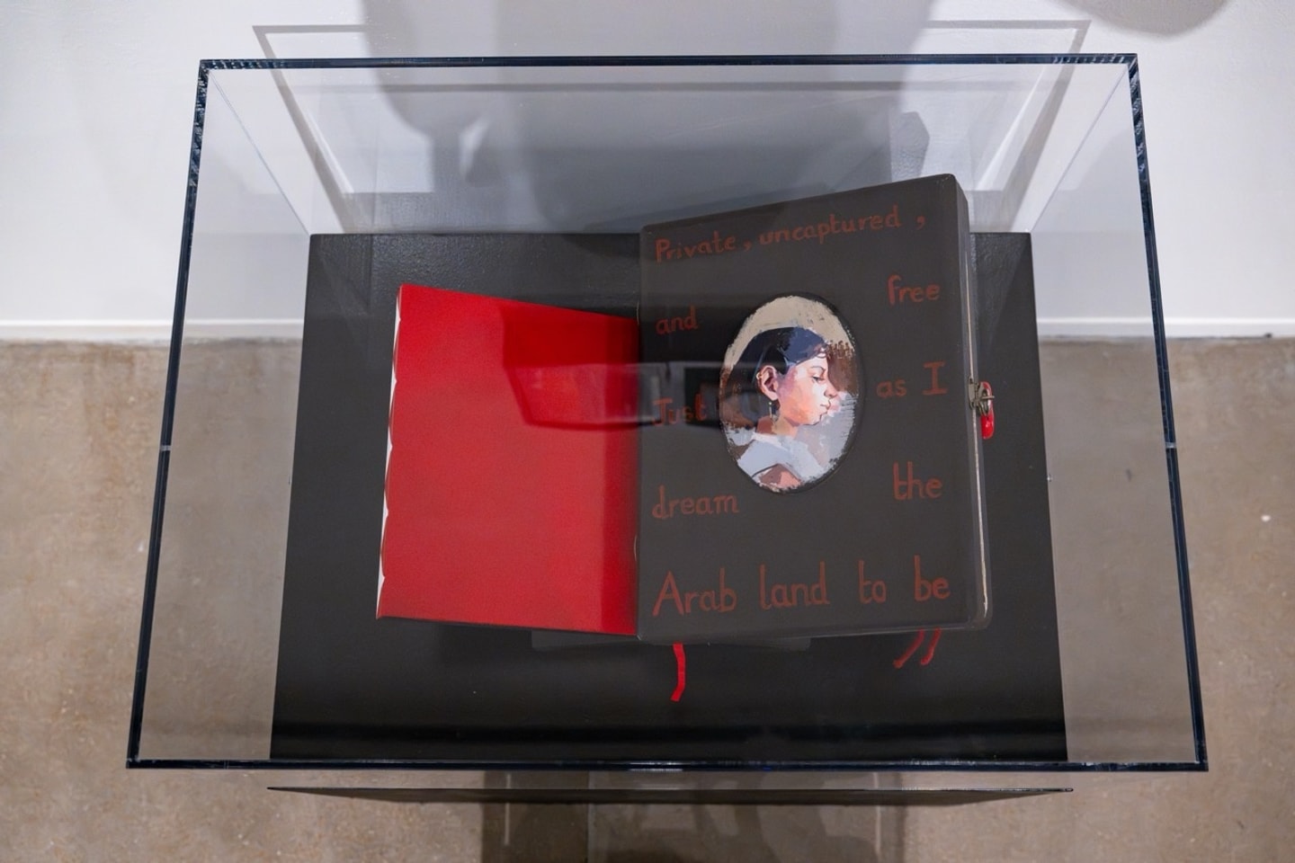 handmade sketchbook opened to a red page and a page with the artist's self portrait