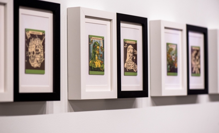 Row of framed color and black-and-white playing card designs for cartoon monsters.