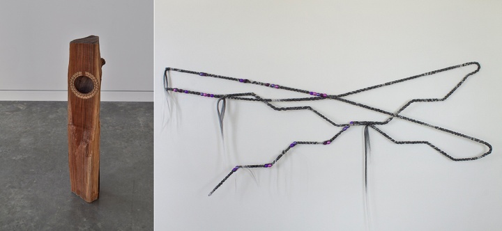 Two sculptures; the left one is a vertically built piece of found wood with a guitar rosette; the right one is a wire-like piece made from steel armature, synthetic hair and beads.