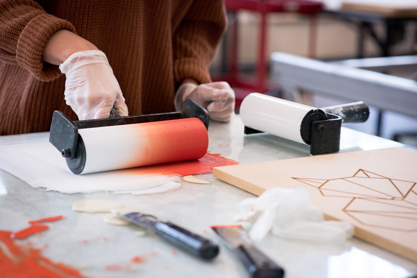 person picking up ink with a roller for printmaking