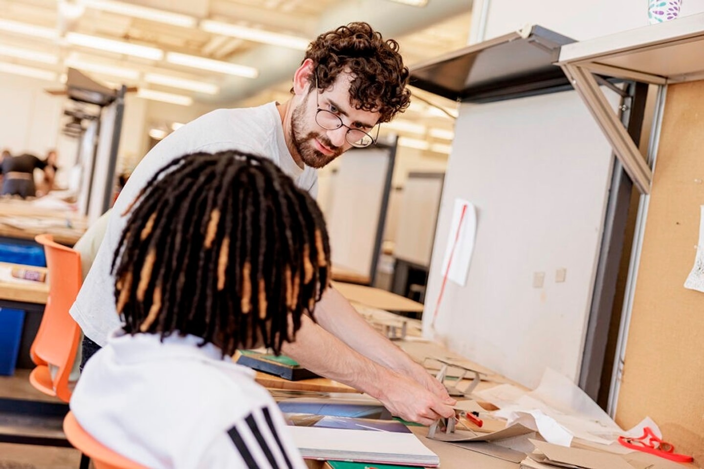 college student working with a camper in the architecture studio