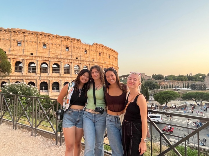 4 girls posing for photo in fron of Roman Colleseum