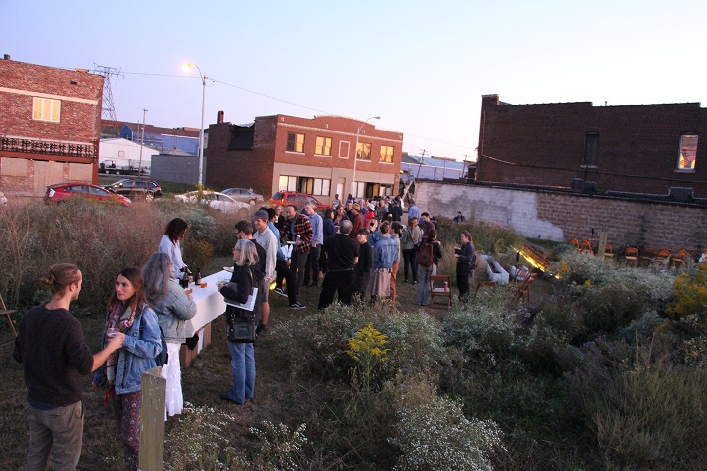 group of people standing in garden near buildings