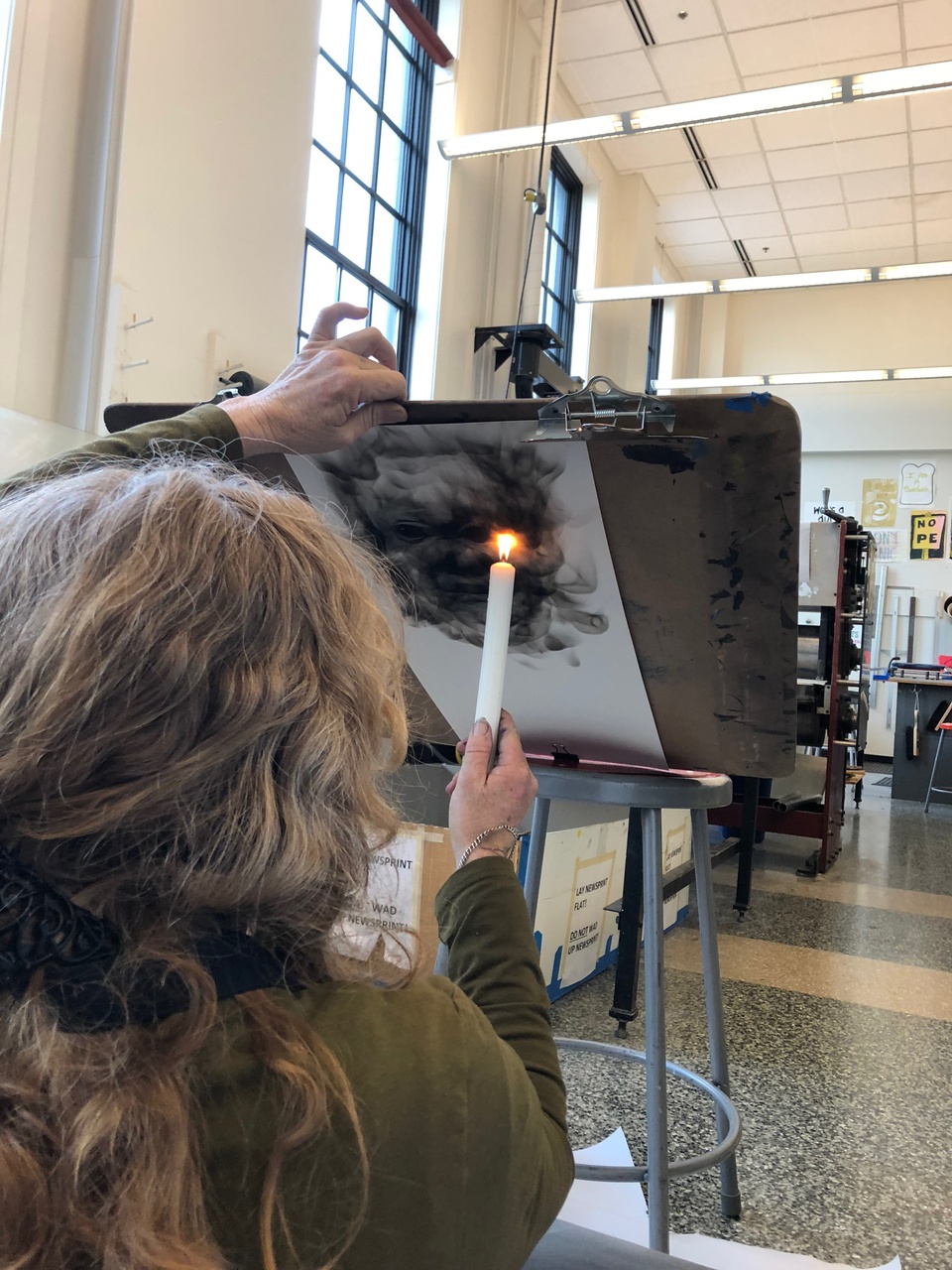 Artist drawing with smoke from a candle.