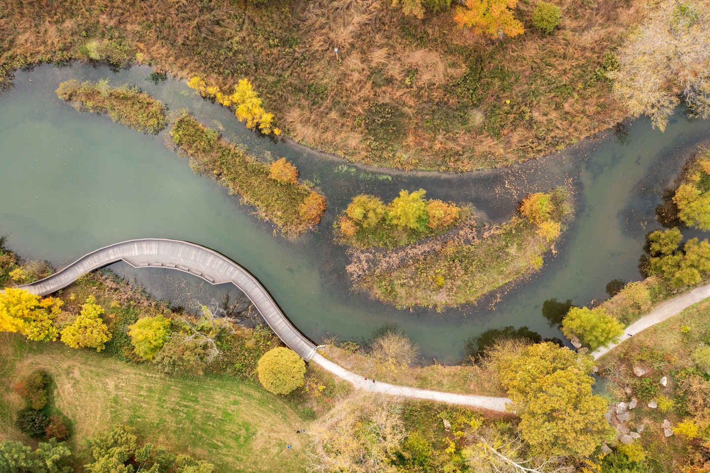 Aerial photo of a river with land on both sides, and a couple of small islands of land in the middle.