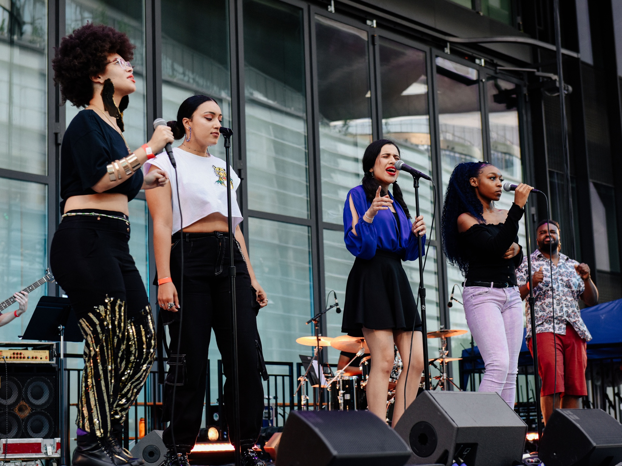 Four women singing on a stage.