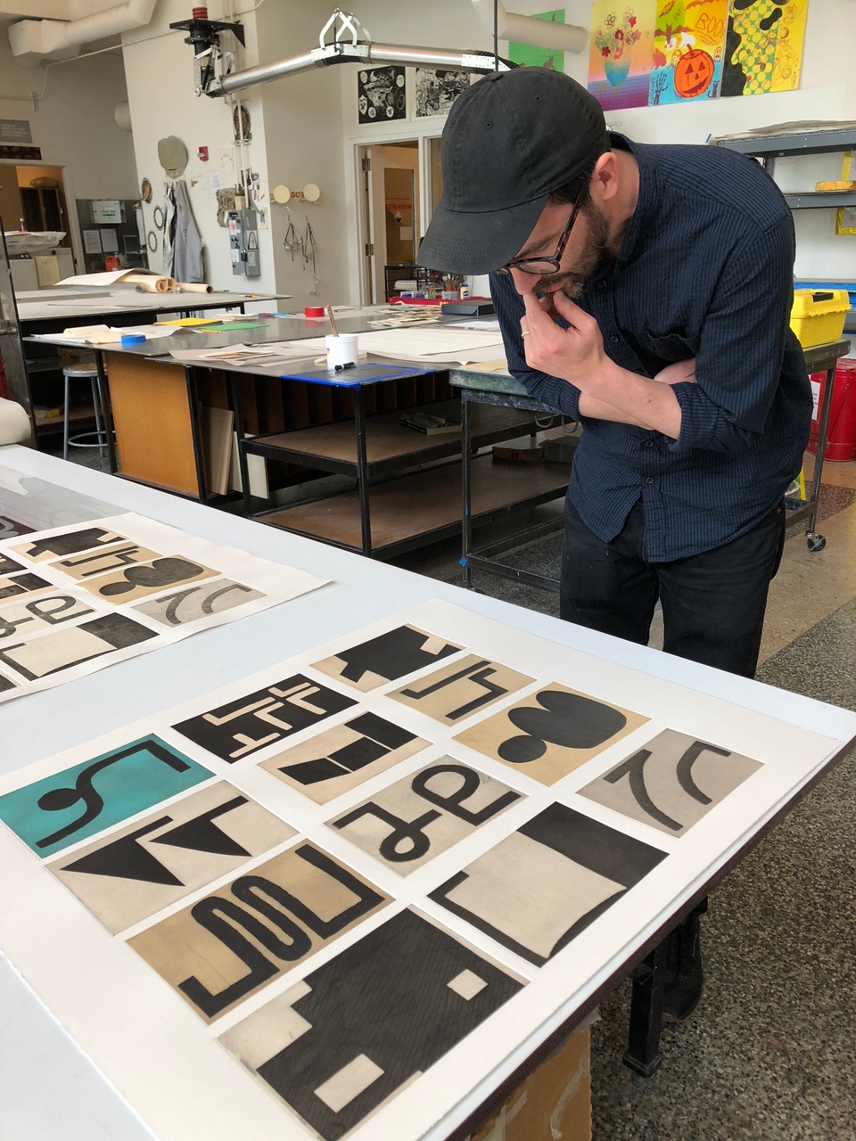 artist looking at finished print on the press bed