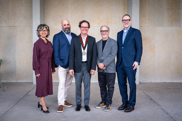 Five people standing together looking at the camera.
