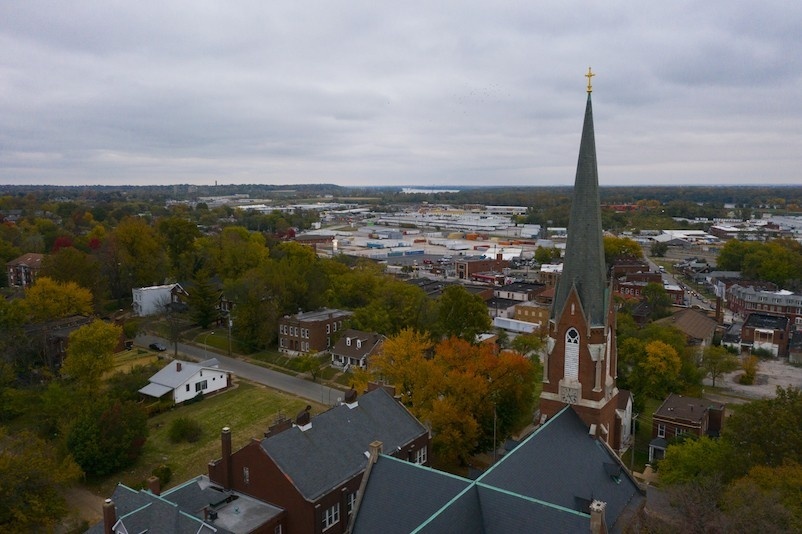 An image of a city neighborhood with buildings and trees, shot from a drone.