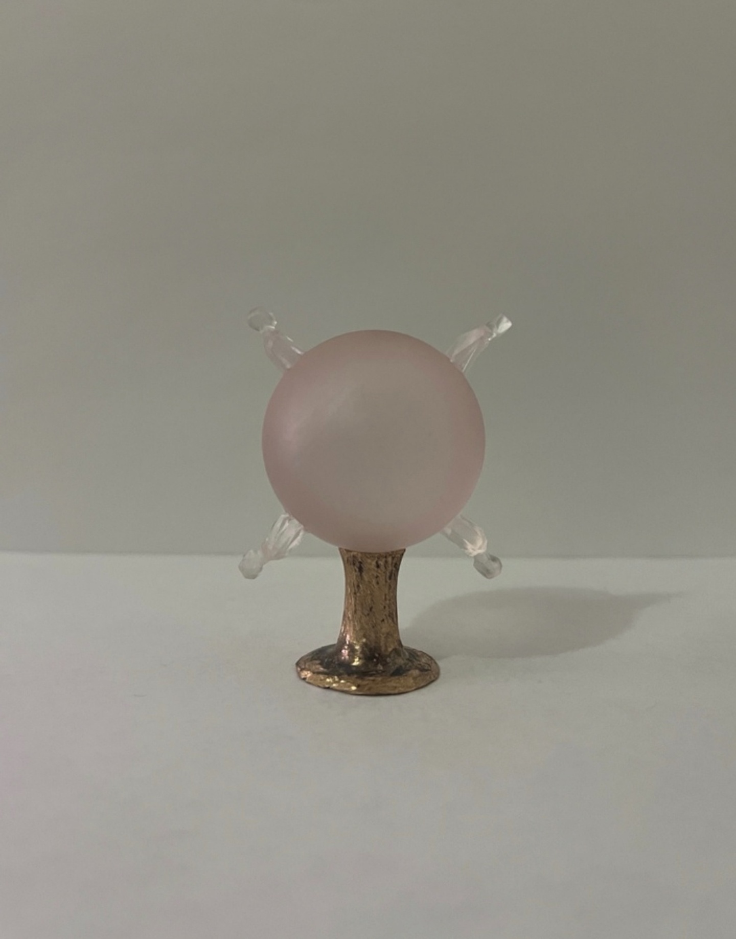 A light pink orb with a golden base.