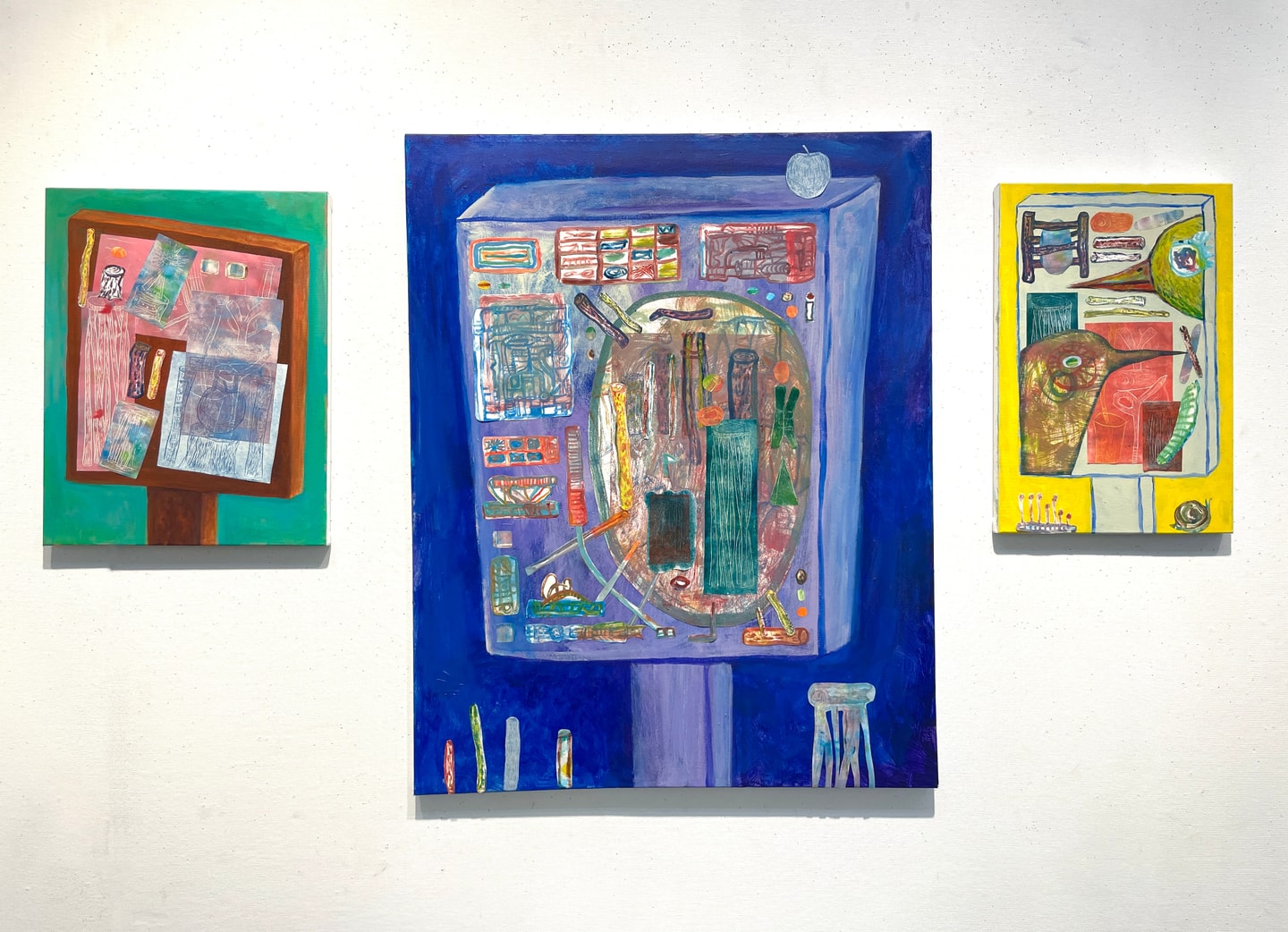 Three abstracted oil paintings, one green, one blue, and one yellow.