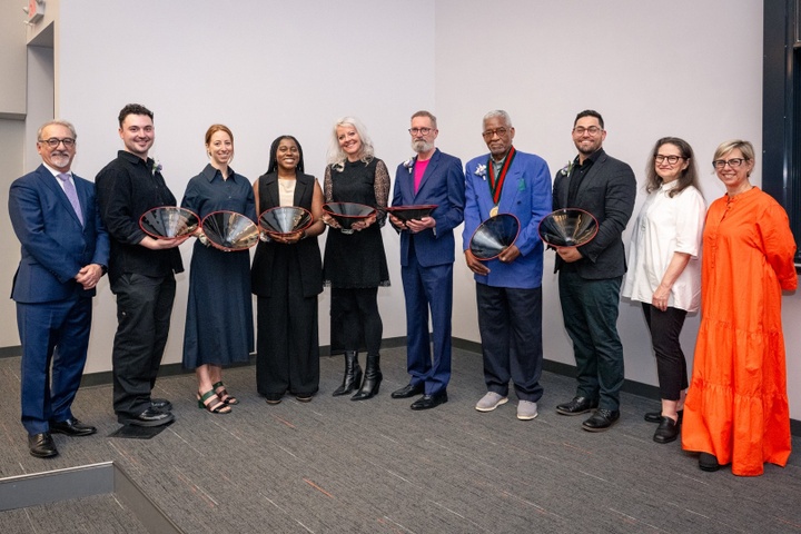 Group of people pose with special black and red glass bowls.