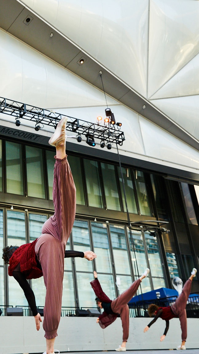 Three dancers doing a standing split kick.