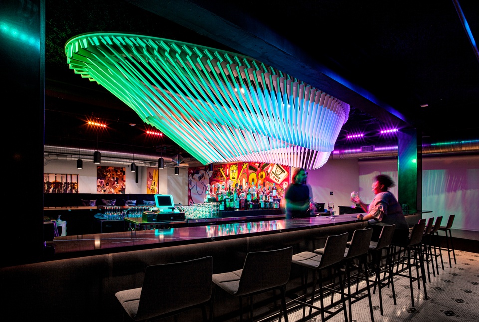 A bar indoors with aurora colored ceiling details