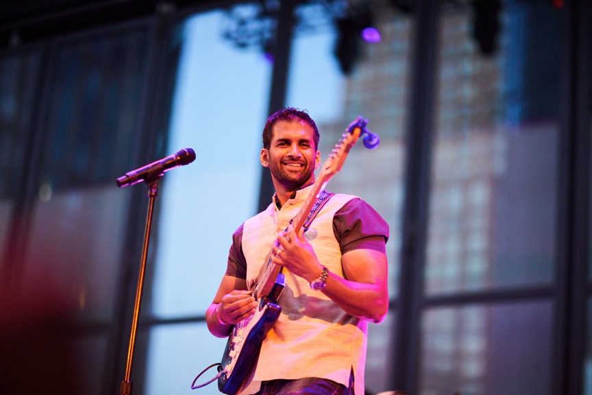 Guitarist playing on outdoor stage.