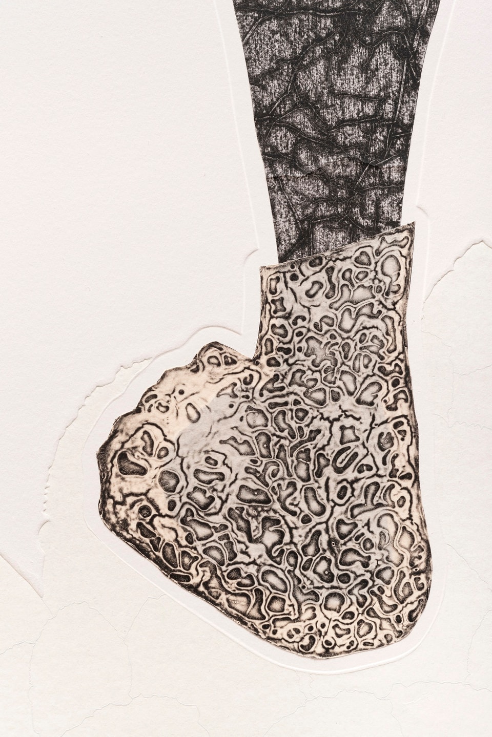 detail of foot of figure with textured printing in black on cream paper with blind embossment around the foot
