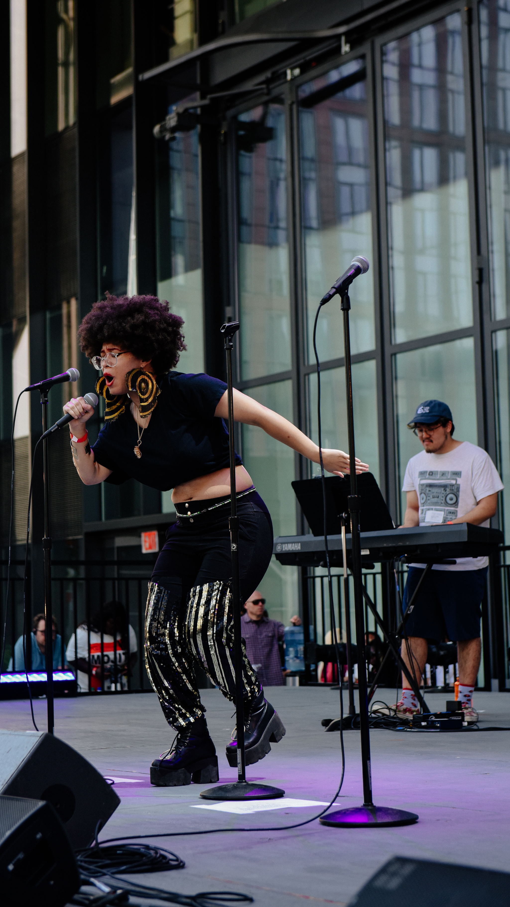 Woman singing on stage with pianist.