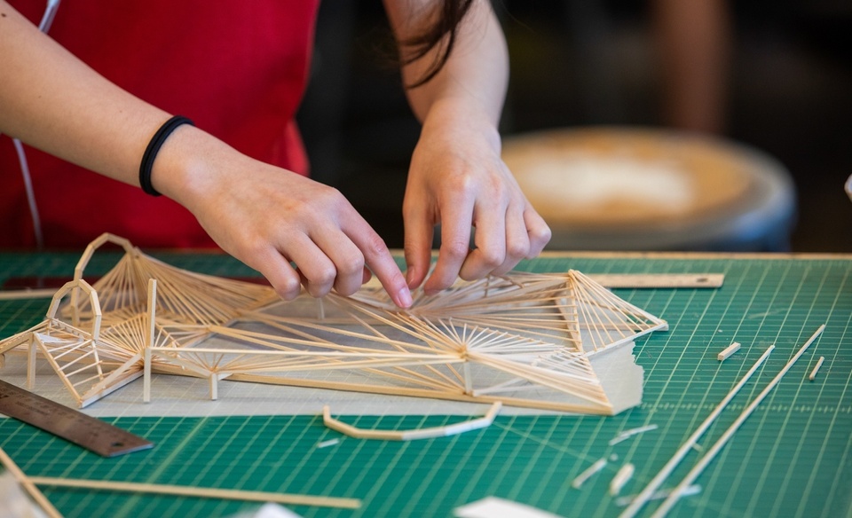 Students arranging pieces of wood into a sculpture