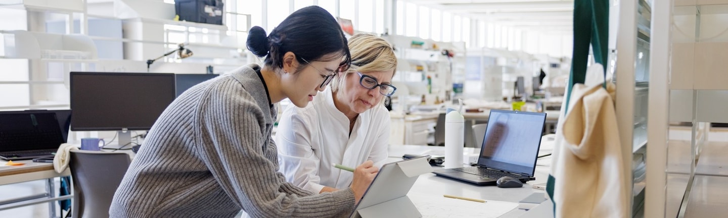 A WashU professor consults with a graduate student at her desk in the graduate studios.