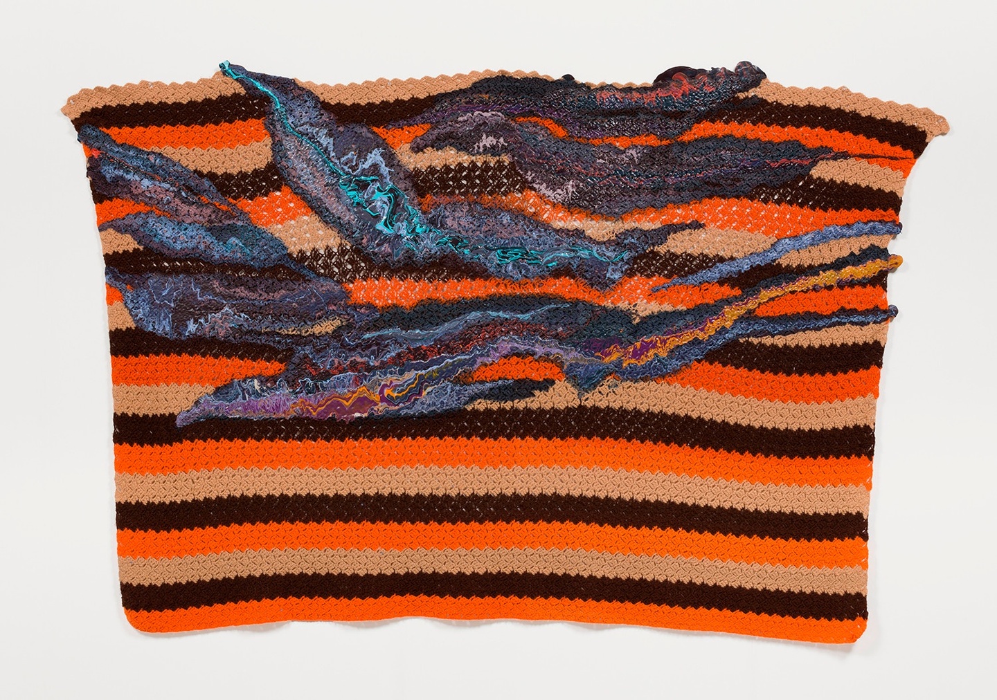A knitted blanket with horizontal stripes and sections of multicolored paint in the top half