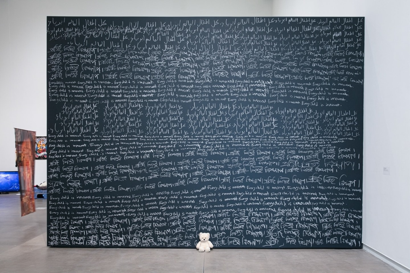 chalkboard wall withe writing and a teddy bear on the floor
