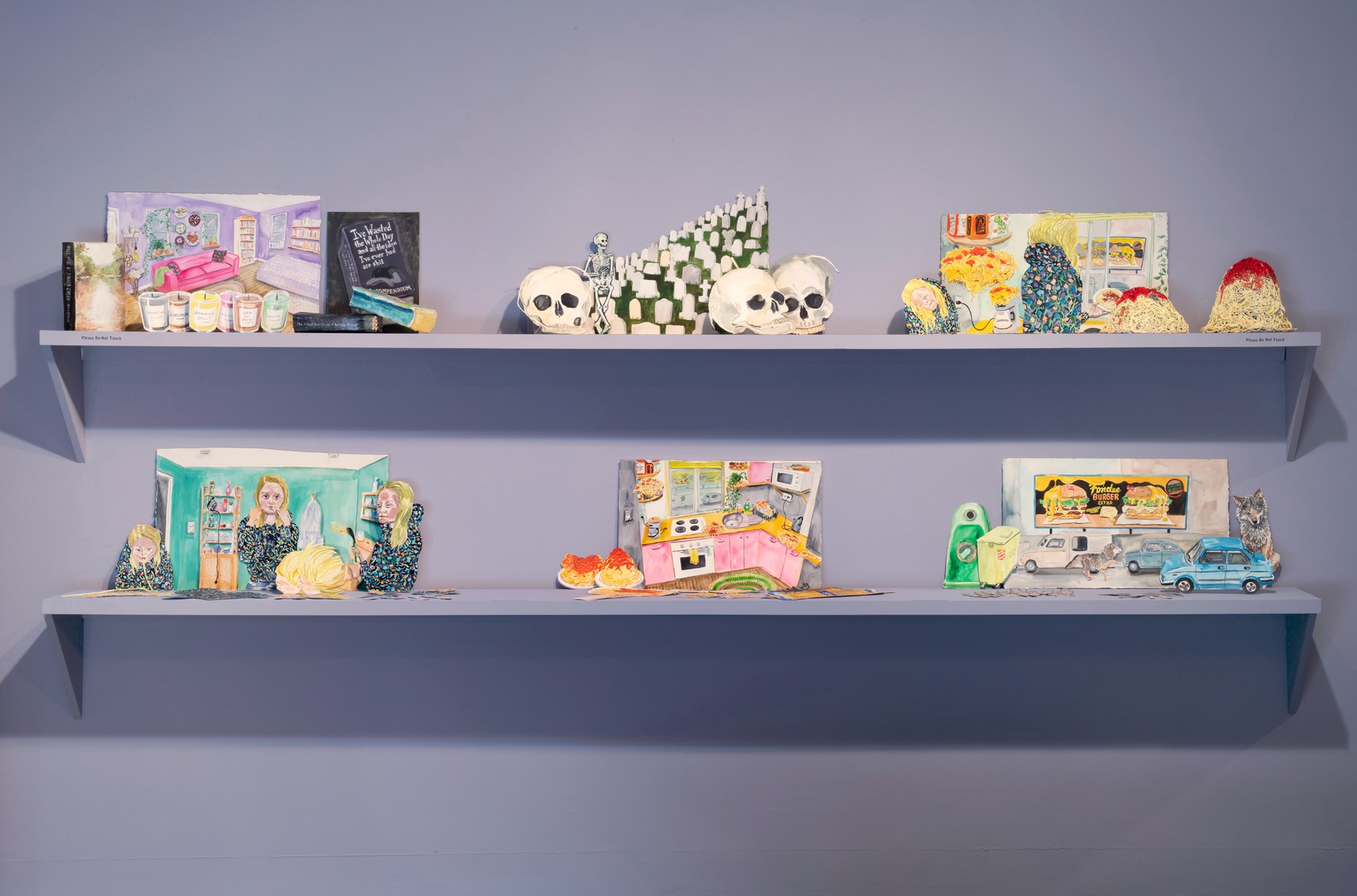 Six colorful scenes made from painted paper cutouts sit on two parallel light purple shelves against a wall of the same color.