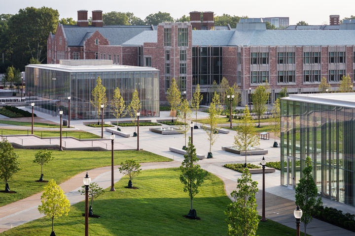 High angled view of a park area between sets of buildings on a college campus, both glass walled modern designs and classic Collegiate Gothic architecture styles.