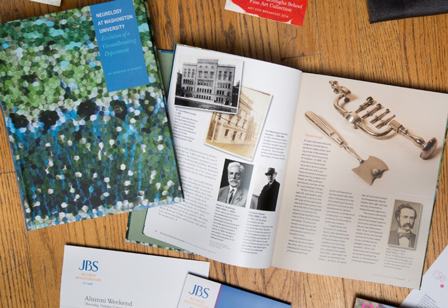 Cover plus an open, interior spread of a neurology book laid out on a table. The cover has green, white. light blue, and dark blue dots; the interior spread has a few historcial photographs of buildings, people, and tools with text.