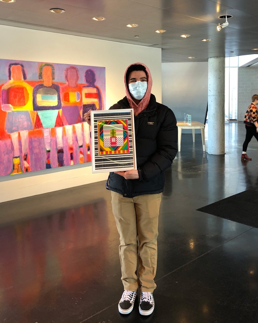 A student holds an abstract artwork from the Tang collection.