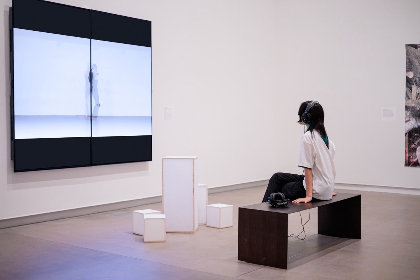 person wearing headphones watching the art installation 