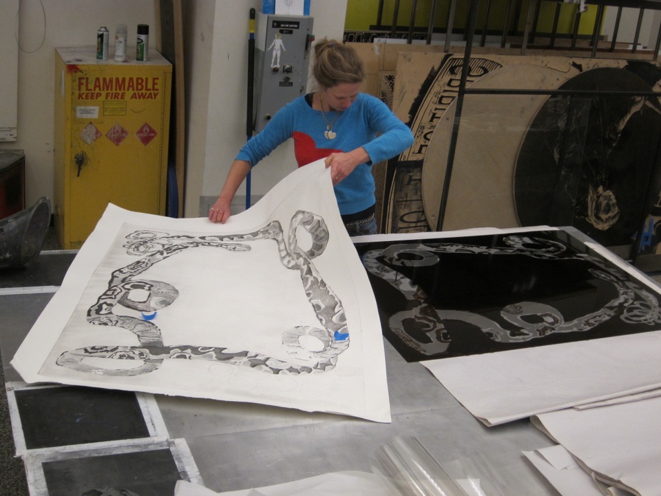 artist moving large print of snake from plate