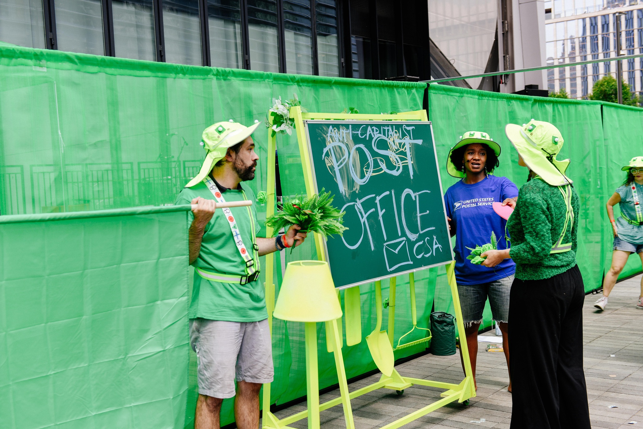 A group of participants in green hats outside The Shed.