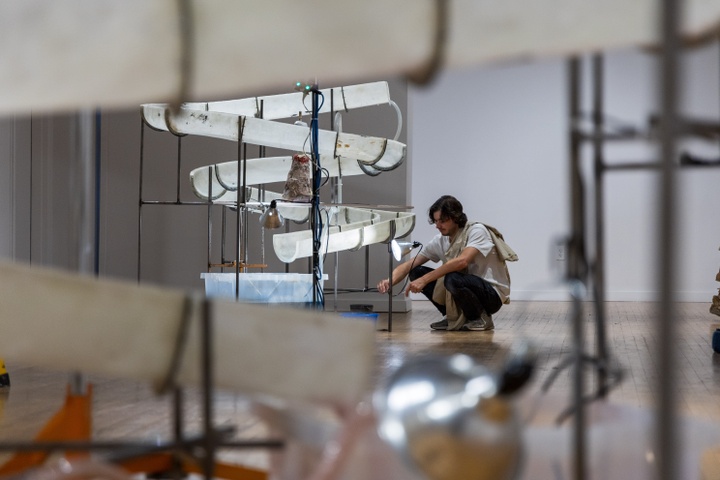 Person crouching down to work on art installation