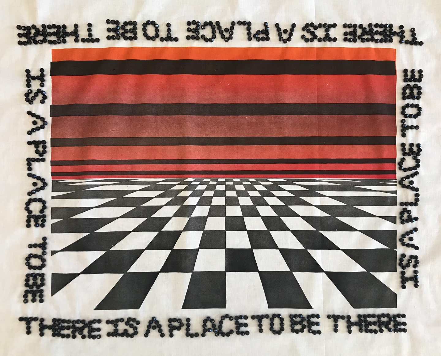 Print on white fabric of a checkerboard floor receding into the distance under a red sky. The words "There is a place to be" are spelled with black beads sewn around the frame of the print, over and over.