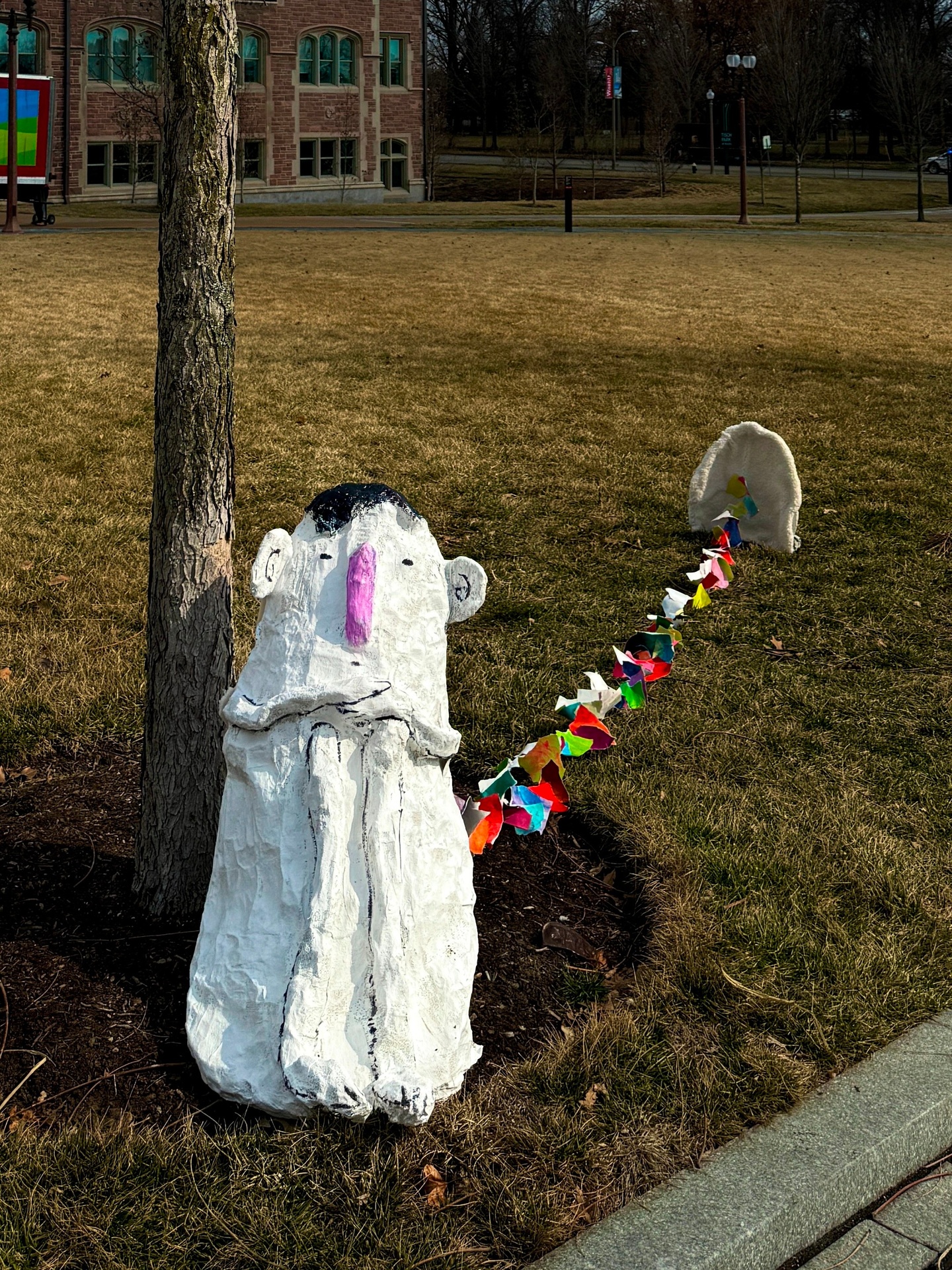 A little white guy stature with a string of paper anchored to a white structure following him.