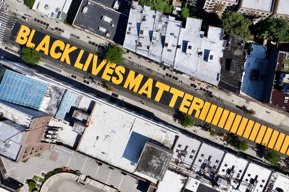 Aerial photo of a mural painted on the street, with the words Black Lives Matter in bold, all-caps yellow.