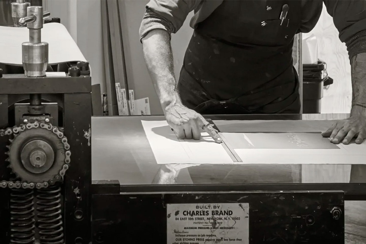 A black and photo of a person making a photogravure print.