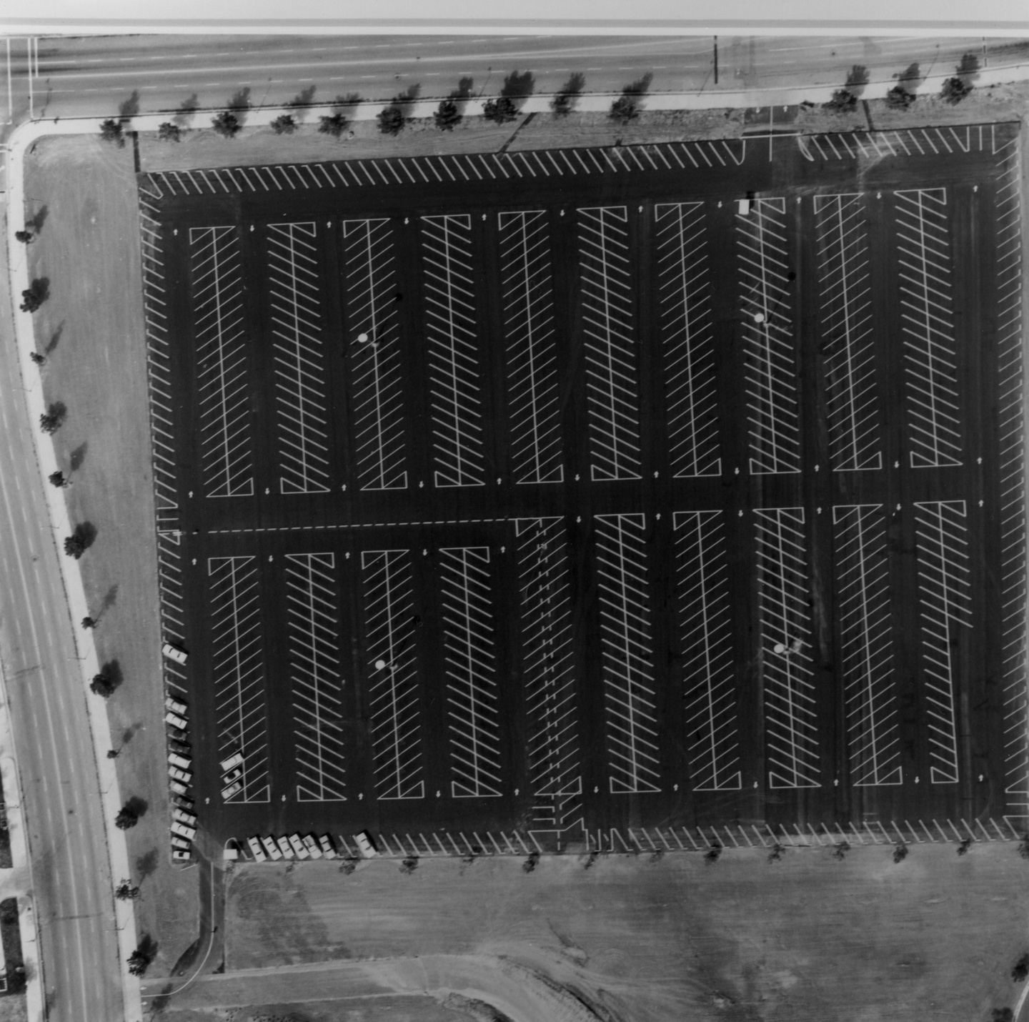 Black and white aerial photo of a massive parking lot, with gridlines for the parking spaces.