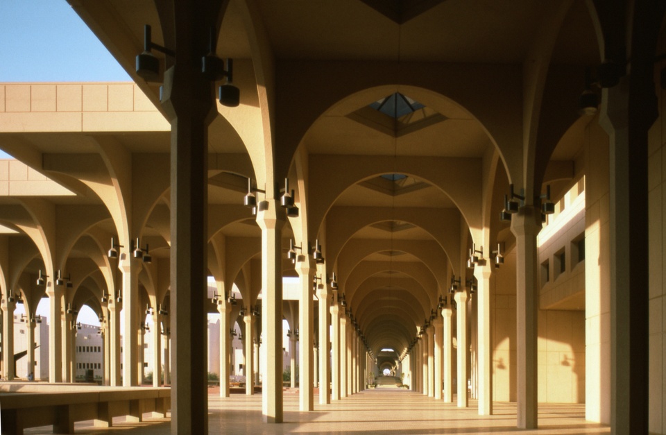 Exterior photo of the outside entrance areas of the university, with a lot of archways with column-like structures.