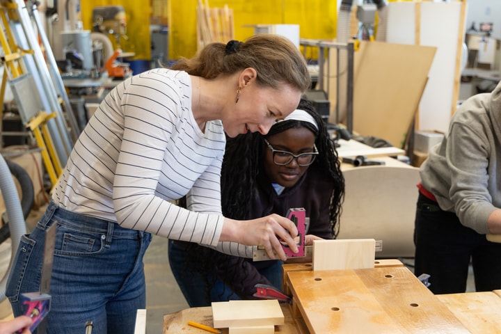 a faculty member showing a student how to create a Japanese wooden box