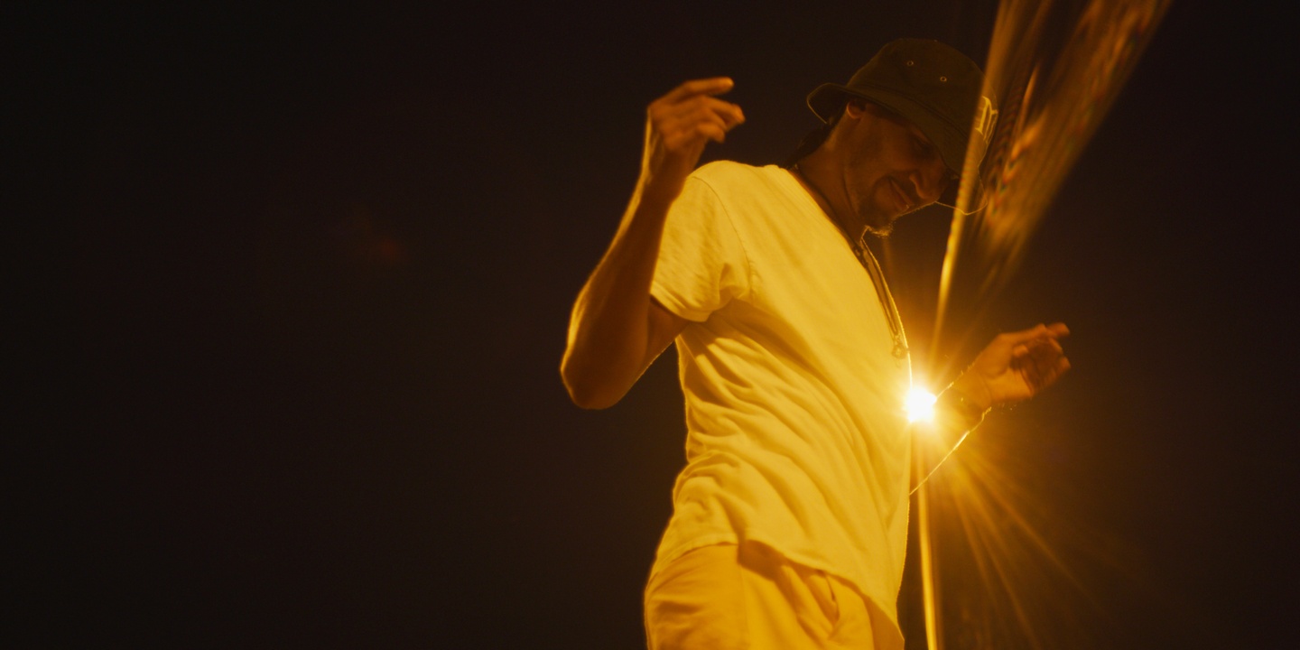 A dancer in the dark with a bright light shining behind him