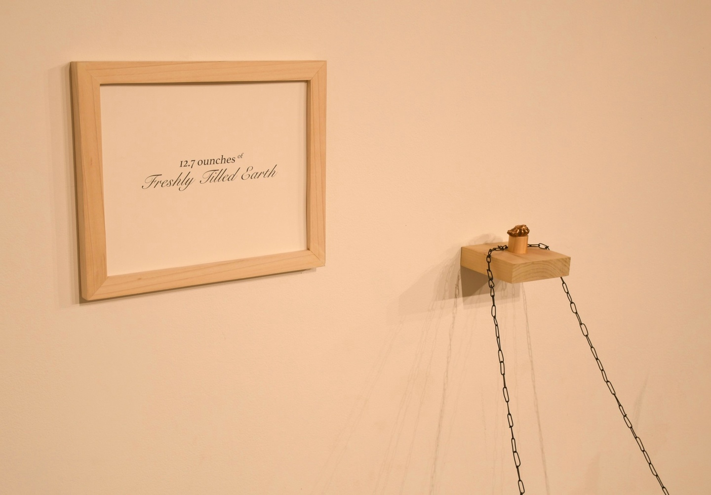 frame sign on wall that say "12.7 oz of freshly tilled earth"