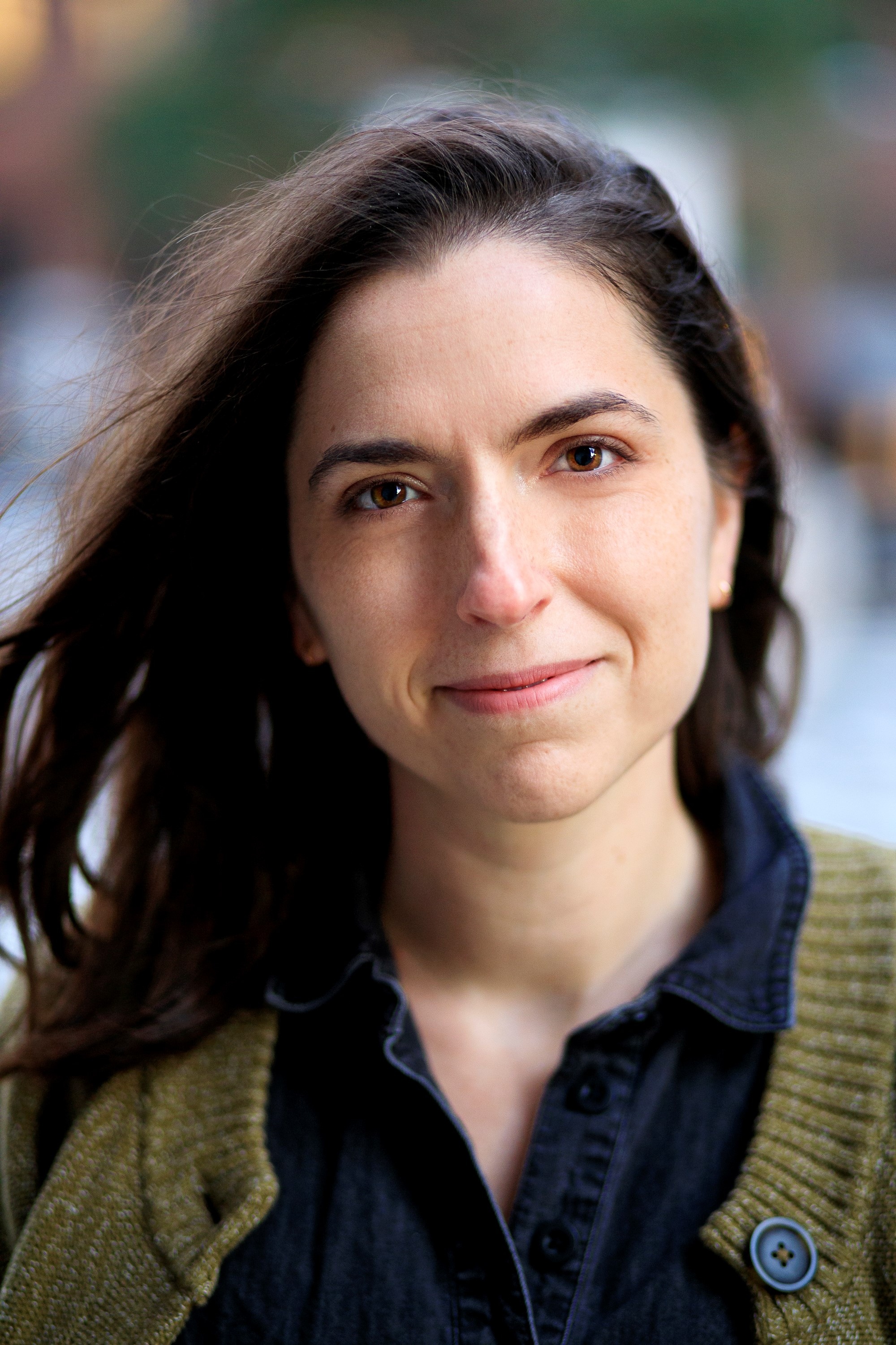 Co-set designer Mary Hamrick wearing a green cardigan with a breeze blowing her shoulder-length brown hair away from the left side of her face