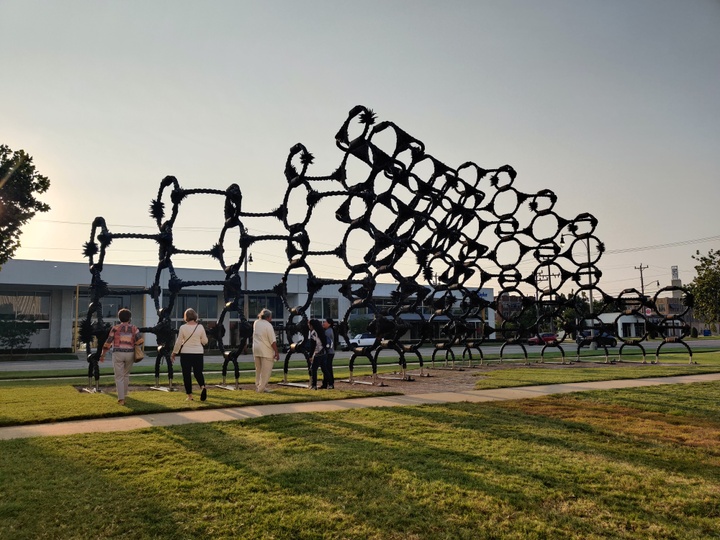 A large, outdoor sculpture composed of modules of circles and lines created from car tires