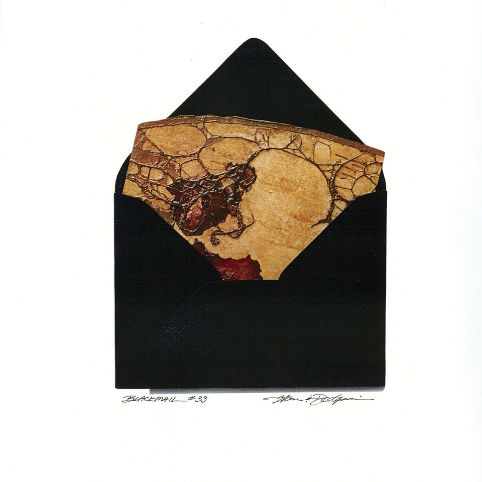 An open black envelope revealing a textured piece of yellowed paper with curved lines and some dark brown and deep red markings.