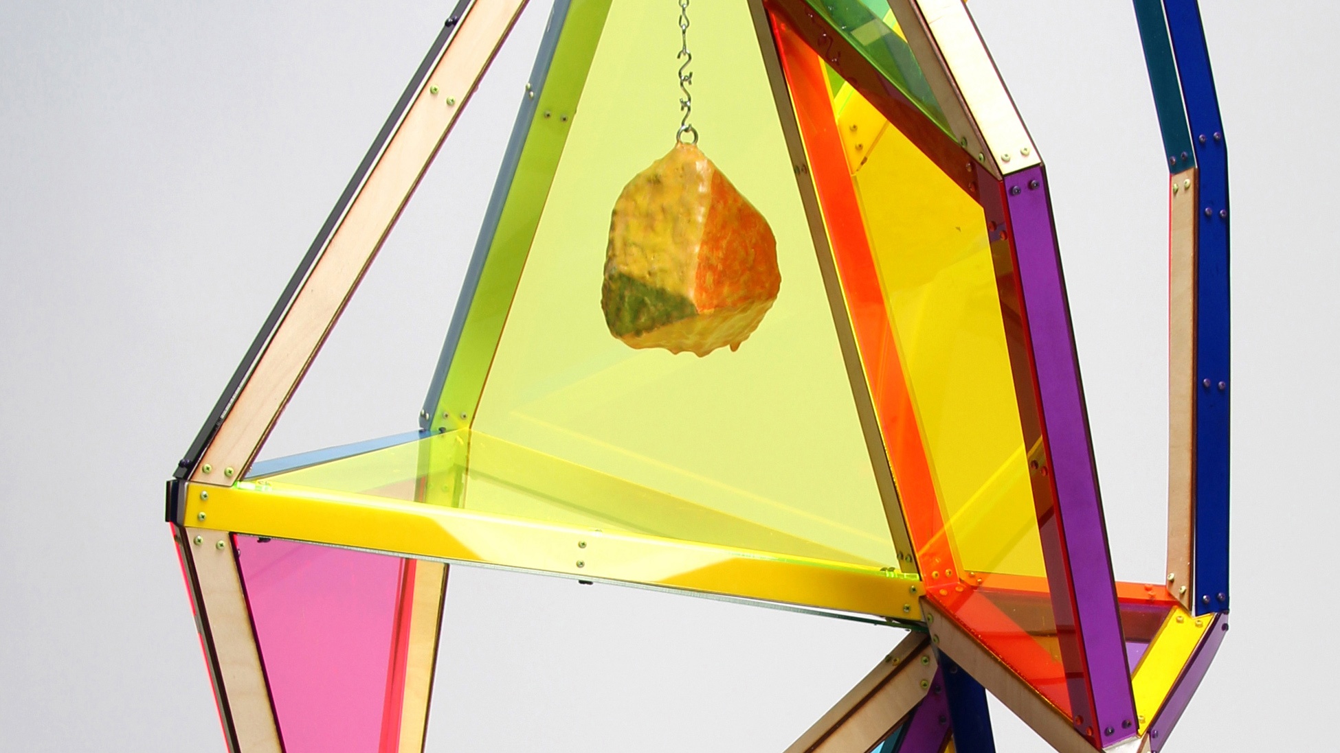 A colorful, geometric sculpture against a light gray background.