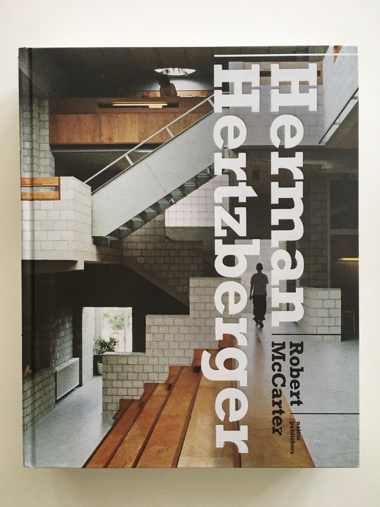 Cover of Herman Hertzberger, featuring the interior of a building with a multi-level staircase, featuring wood steps and light brick surroundings.