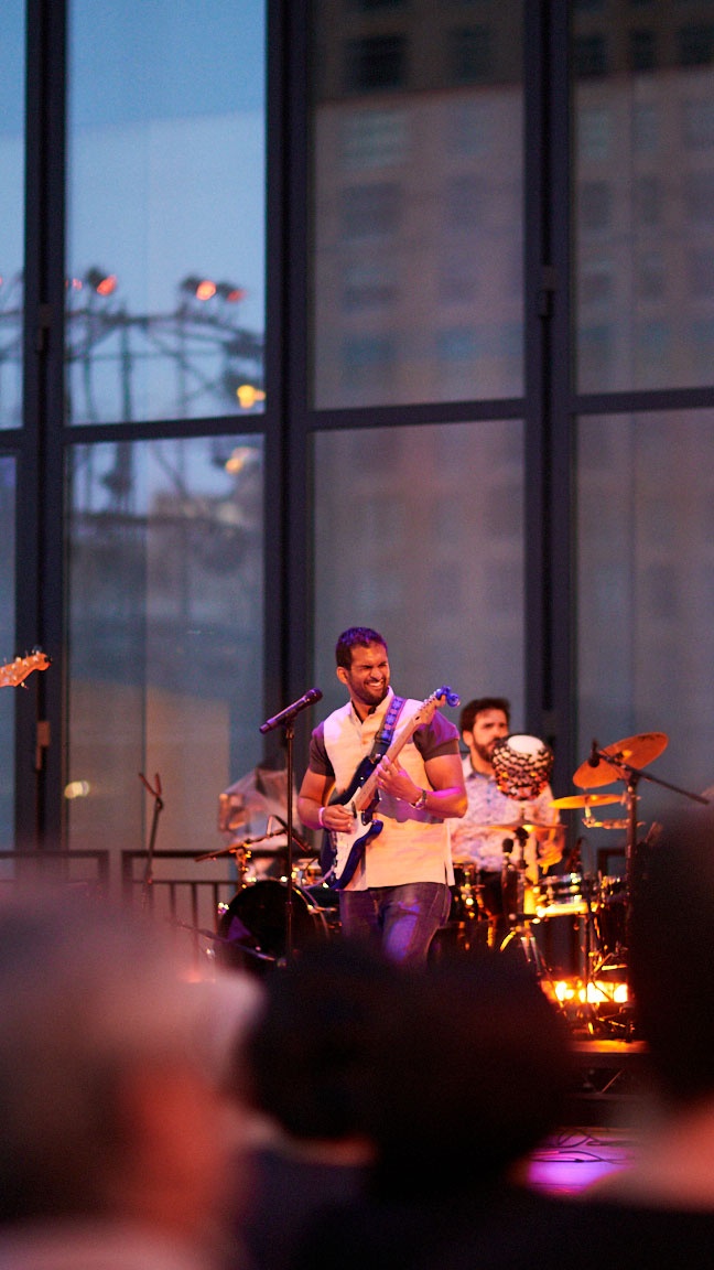 Men playing live instruments on a stage.